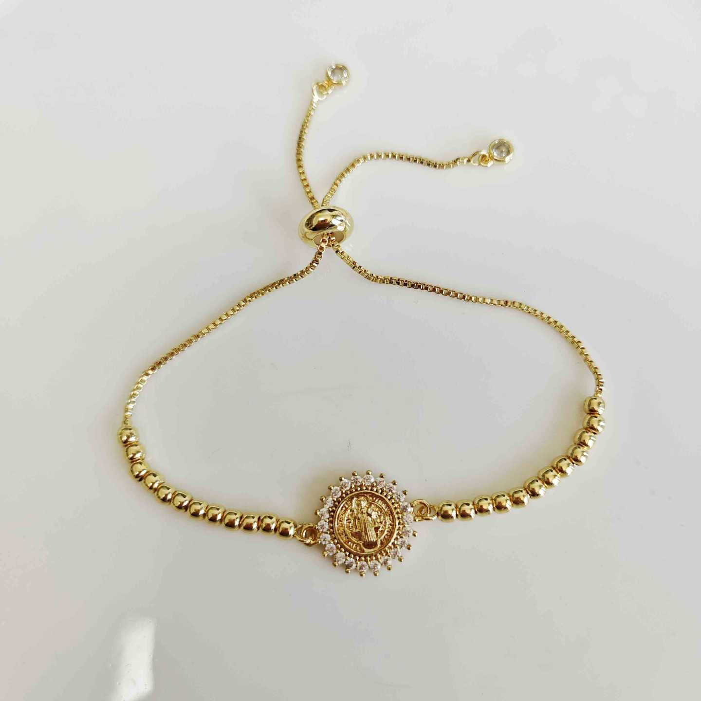Pulsera Bañada en Oro 18k Medalla San Benito Halo Circones Corona Bolitas Bolo Ajustable